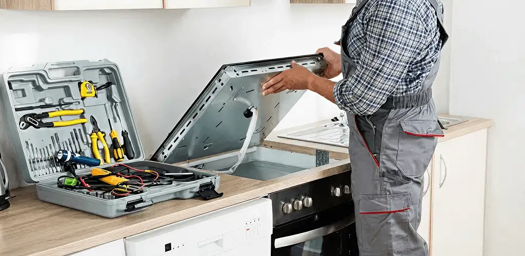 Handyman repairing a cooktop and checking wiring connections in San Antonio, TX