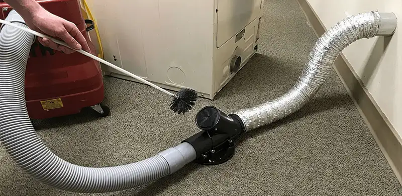 Dryer vent cleaning service removing lint from a dryer duct connection in San Antonio, TX