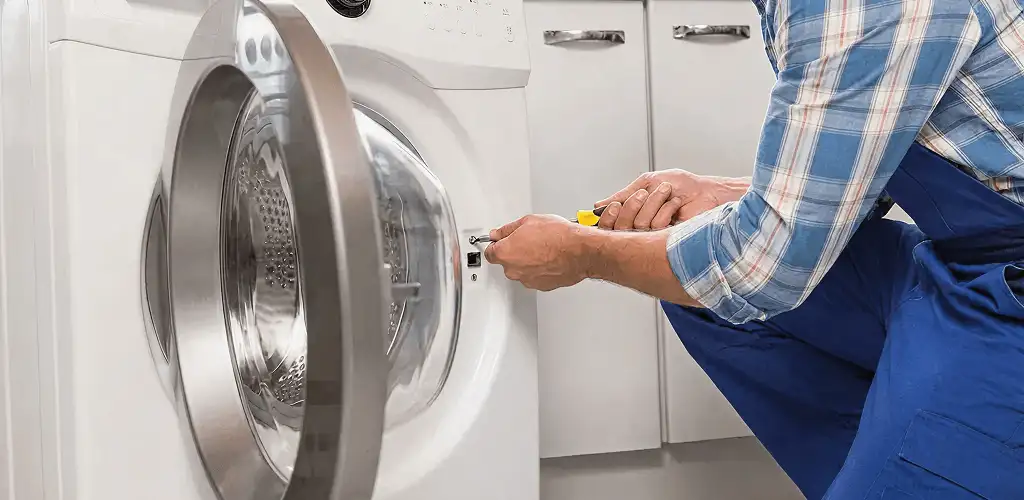 Handyman repairing a clothes dryer and checking electrical connections in San Antonio, TX