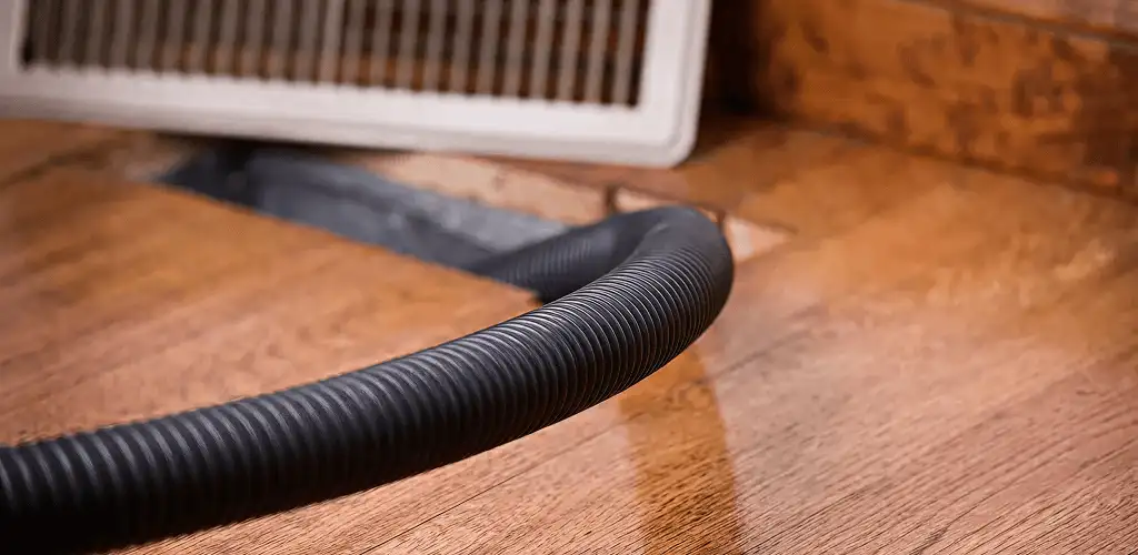 Air duct cleaning hose inserted into a floor vent for ductwork cleaning in San Antonio, TX